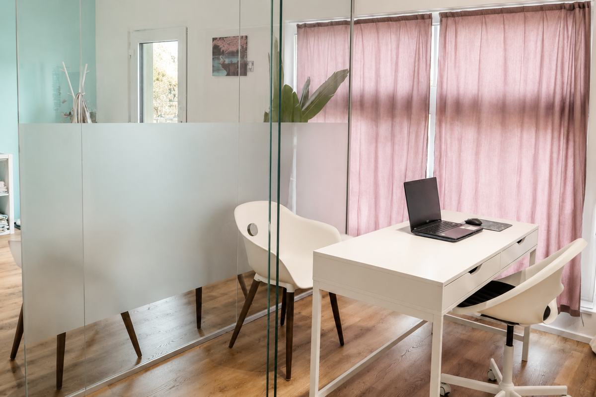 Besprechungszimmer mit Schreibtisch hinter der Glaswand in der Massagepraxis Biberist